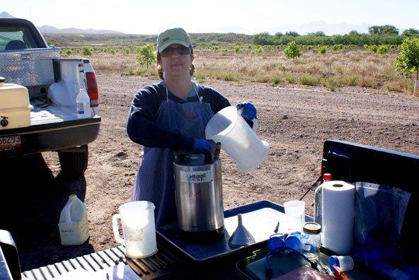 Image of ...Marisa Thompson Mixing Chemical Treatments (Photo by 2009 Weed Science Field Crew)